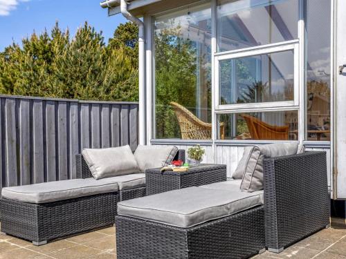 a patio with two wicker chairs and a table at Holiday Home Solvejk - 800m from the sea by Interhome in Vejers Strand