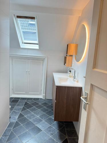 a bathroom with a sink and a window at De Stadshoeve in Medemblik