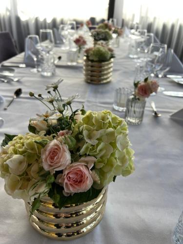 a vase filled with pink and white flowers on a table at Thon Hotel Oslo Airport in Gardermoen