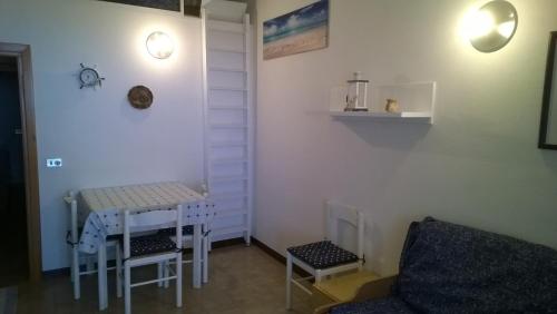 a small room with a table and chairs and a couch at Appartamento Residence Isola Rossa in Isola Rossa