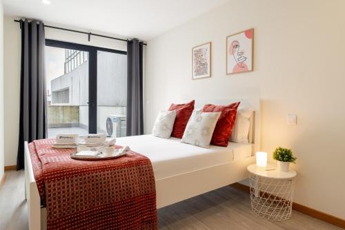a bedroom with a bed and a large window at Modern & Sleek Flat | Terrace & Garage by HostWise in Porto