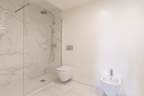 a bathroom with a shower and a toilet and a sink at Modern & Sleek Flat | Terrace & Garage by HostWise in Porto
