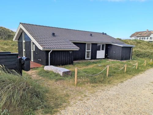 a house on the side of a dirt road at Holiday Home Asvalde - 150m from the sea by Interhome in Vejers Strand