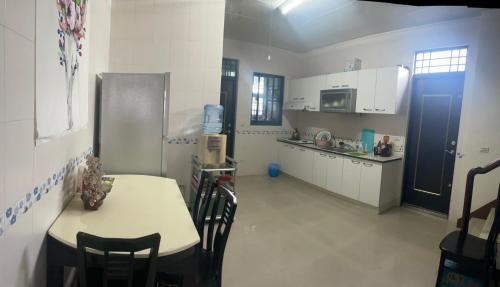 une cuisine avec une table et des placards blancs dans l'établissement Dong Wang Homestay, à Taïtung