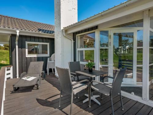 a patio with chairs and a table on a deck at Holiday Home Domna - 800m from the sea by Interhome in Blåvand