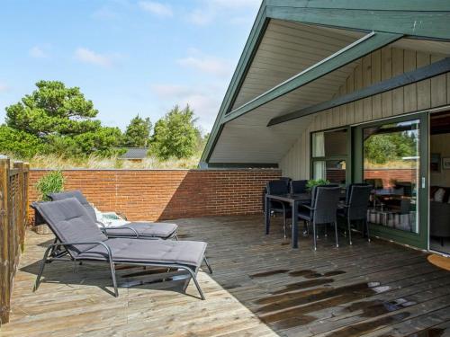 une terrasse avec des chaises et une table sur une maison dans l'établissement Holiday Home Görel - 1km from the sea by Interhome, à Blåvand