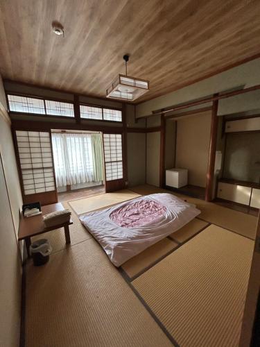 a bedroom with a bed in a room with windows at Chikotto Inn in Kumano