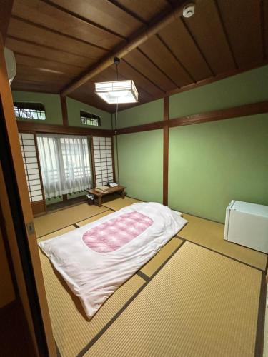 a room with a bed in the corner of a room at Chikotto Inn in Kumano