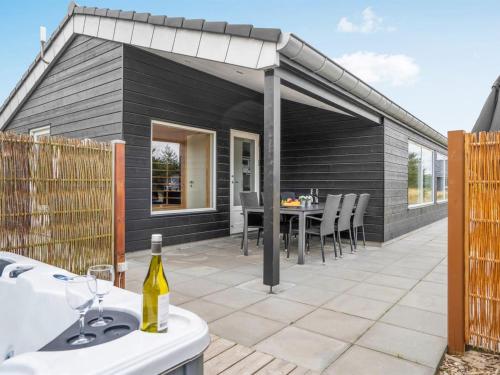 un patio avec une table et des chaises et un bâtiment dans l'établissement Holiday Home Soili - 1-2km from the sea by Interhome, à Blåvand