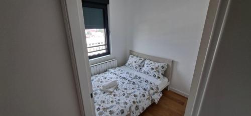 a small bedroom with a bed and a window at Park Vila apartment in Belgrade