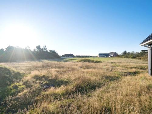 un champ ouvert avec une maison en arrière-plan dans l'établissement Holiday Home Tinemarie - 200m from the sea by Interhome, à Blåvand