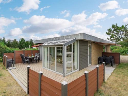 une maison modulaire avec une terrasse avec une table et des chaises dans l'établissement Holiday Home Skakke - 900m from the sea by Interhome, à Blåvand