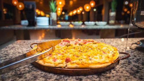 a pizza sitting on top of a table at Pousada Itajuípe- Unidade Itabuna-Ba in Itabuna