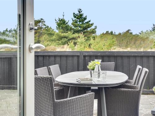 une table blanche et des chaises sur une terrasse dans l'établissement Holiday Home Vladan - 1-6km from the sea by Interhome, à Blåvand