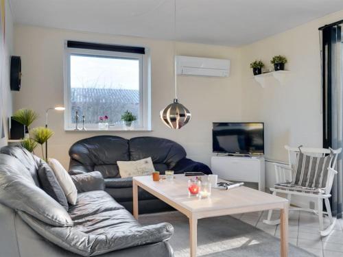 a living room with a couch and a table at Holiday Home Dværg - 350m from the sea by Interhome in Ringkøbing