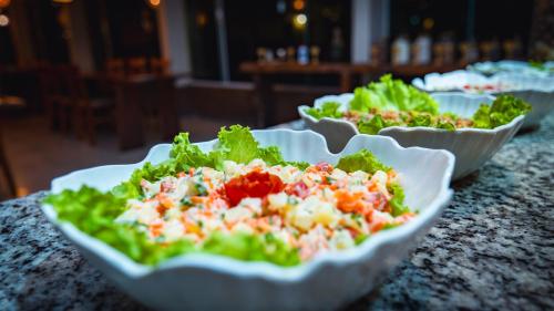 three salads in white bowls on a table at Pousada Itajuípe- Unidade Itabuna-Ba in Itabuna