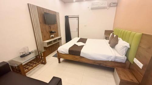 a bedroom with a bed and a television in it at SEA VIEW & SWIMMING POOL HOTEL SGHR ! PURi Air-Conditioned Rooms with Balconies, Restaurant, LIFT & Free Wi-Fi - Best Hotel In Puri in Puri