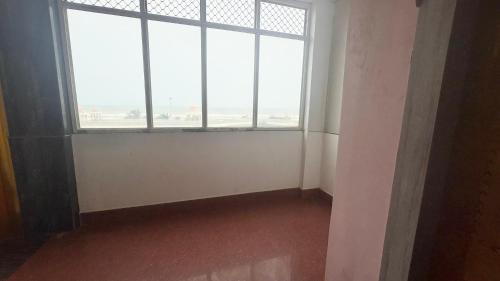 an empty room with a large window in an airport at SEA VIEW & SWIMMING POOL HOTEL SGHR ! PURi Air-Conditioned Rooms with Balconies, Restaurant, LIFT & Free Wi-Fi - Best Hotel In Puri in Puri
