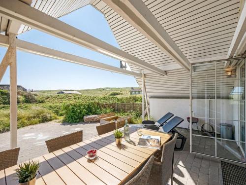a patio with a table and chairs on a deck at Holiday Home Klimentina - 150m from the sea by Interhome in Ringkøbing