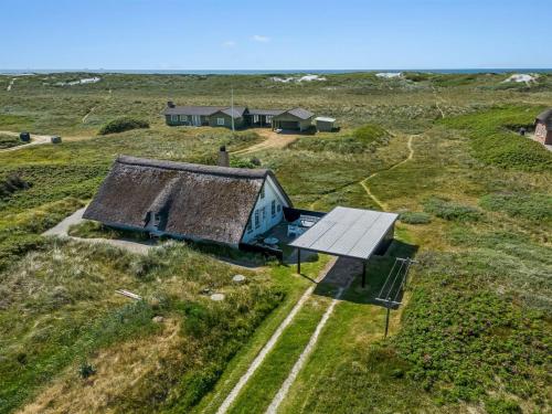 an old house in a field with a solar panel at Holiday Home Klimentina - 150m from the sea by Interhome in Ringkøbing