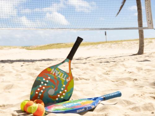 a beach volleyball racket and ball in the sand at Hotel Varandas Beach in Águas Belas