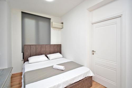 Un dormitorio con una cama grande con sábanas blancas. en Aparthotel Near Northern Avenue, en Ereván