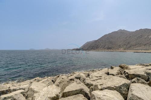 a group of rocks on the shore of a body of water at Villa with Private Pool, Near Reef Oasis Diving Center And Just Minutes from Address Beach Resort, Al Dana Island, Fujairah in Fujairah