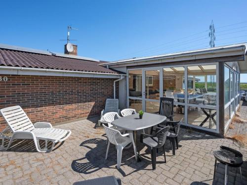 a patio with a table and chairs and a building at Holiday Home Nanette - 300m to the inlet by Interhome in Ringkøbing