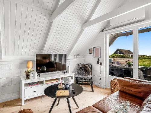 a living room with a television and a table at Holiday Home Hen - 400m from the sea by Interhome in Ringkøbing