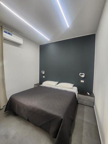 a bedroom with a bed with a black wall at Naxos Blu Appartament in Giardini Naxos