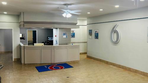 an empty lobby with a reception desk and a ceiling fan at Motel 6 Cornwall, ON in Cornwall