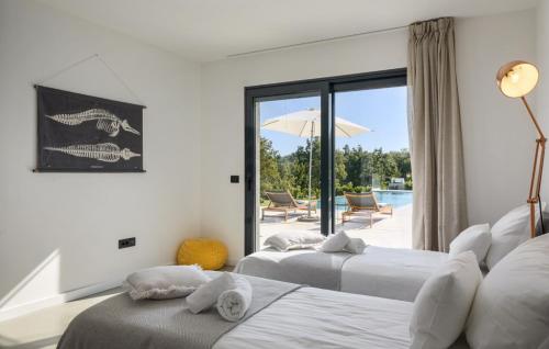 two beds in a room with a view of a pool at Villa OX by Villas Guide in Brajkovići