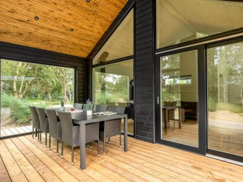 a dining room with a table and chairs on a deck at Holiday Home Edmond - 995m from the sea by Interhome in Ringkøbing