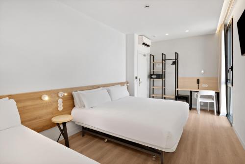 a bedroom with a white bed and a desk at B&B HOTEL Alicante Aeropuerto in Alicante