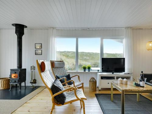 a living room with a chair and a fireplace at Holiday Home Martti - from the sea by Interhome in Bjerregård
