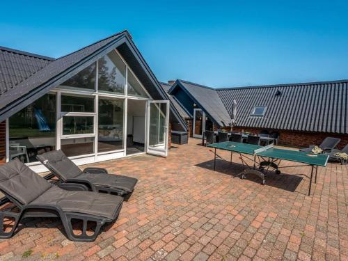eine Terrasse mit einer Tischtennisplatte und Stühlen in der Unterkunft Holiday Home Lidija - 850m from the sea by Interhome in Ringkøbing