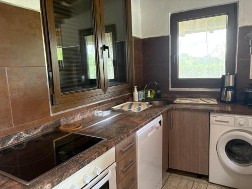 a kitchen with a sink and a washing machine at Agroturismo Gure Naia in Carranza