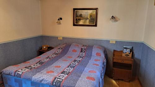 a bedroom with a bed and a picture on the wall at Le chant de la rivière in Carla-de-Roquefort