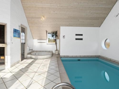 a bathroom with a swimming pool and a tub at Holiday Home Lemmikki - 1-5km from the sea by Interhome in Ringkøbing