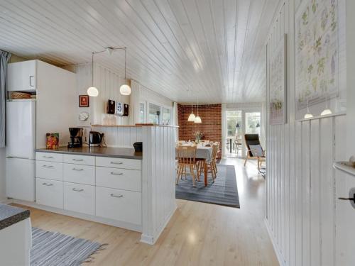 a kitchen with white cabinets and a dining room at Holiday Home Shalez - from the sea by Interhome in Bjerregård