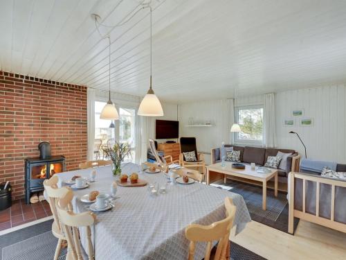a dining room and living room with a table and a fireplace at Holiday Home Shalez - from the sea by Interhome in Bjerregård