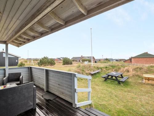 eine Terrasse mit einem Picknicktisch und einem Picknicktisch in der Unterkunft Holiday Home Trineke - from the sea by Interhome in Hvide Sande