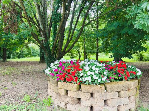 a brick wall with flowers in a park at Casa fiorita in Camisano Vicentino