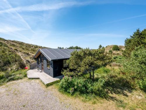 ein kleines Haus mit einer Veranda und einer Terrasse in der Unterkunft Holiday Home Sila - 800m from the sea by Interhome in Hvide Sande