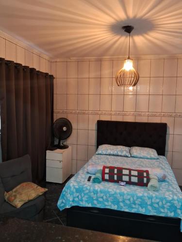 ein Schlafzimmer mit einem Bett, einer Lampe und einem Stuhl in der Unterkunft lar doce lar hospedaria 1 in Guarulhos