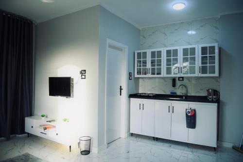 a kitchen with white cabinets and a sink at Paradise House Holiday in Luxor