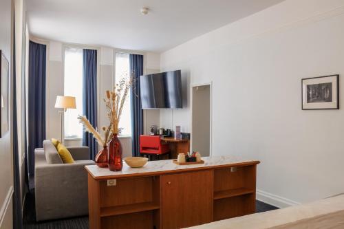a living room with a couch and a table at Mercure Rouen Centre Cathédrale in Rouen