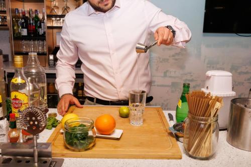 a man standing in a kitchen preparing food on a cutting board at Mercure Rouen Centre Cathédrale in Rouen