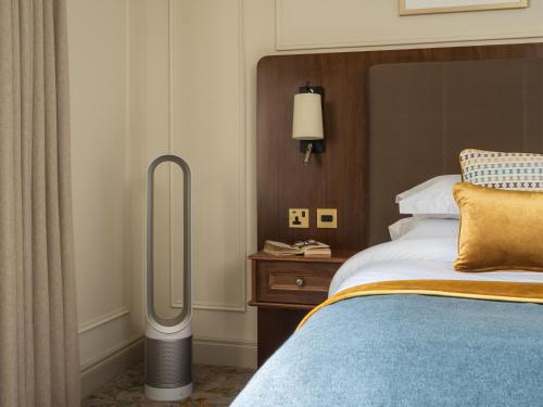 a hotel room with a bed and a floor fan at Lough Erne Resort in Enniskillen