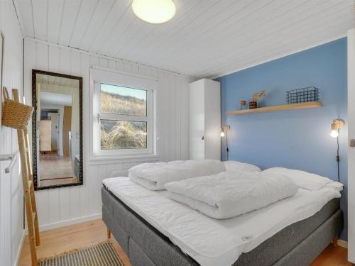 a bedroom with a large white bed with a window at Holiday Home Assa - from the sea by Interhome in Hvide Sande